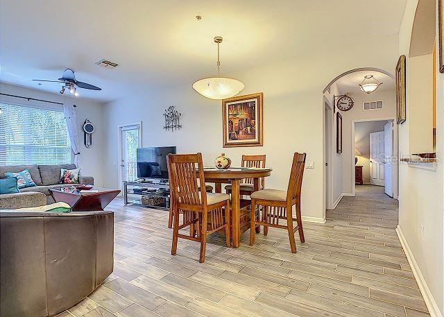 4862 Cayview Avenue, Unit 20909 Orlando, FL 32819 - Photo 9 of 38 a view of a dining room with furniture and wooden floor