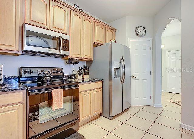 4862 Cayview Avenue, Unit 20909 Orlando, FL 32819 - Photo 10 of 38 a kitchen with stainless steel appliances granite countertop a refrigerator and a stove top oven