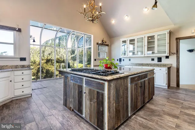 a open kitchen with granite countertop a stove top oven a sink and cabinets