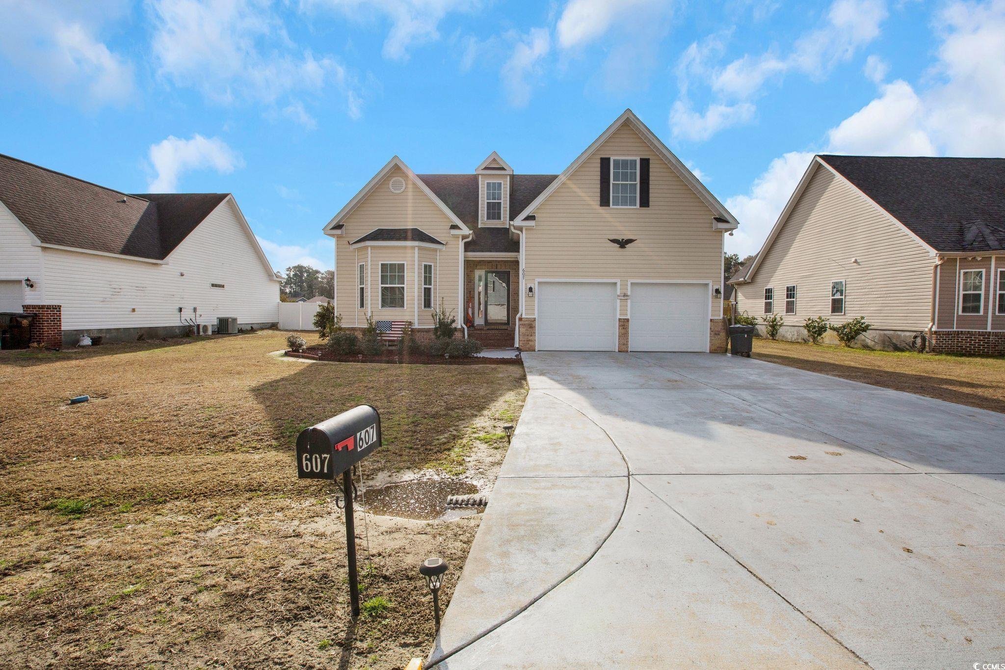 View of front of home featuring a garage, central AC unit, and a front lawn