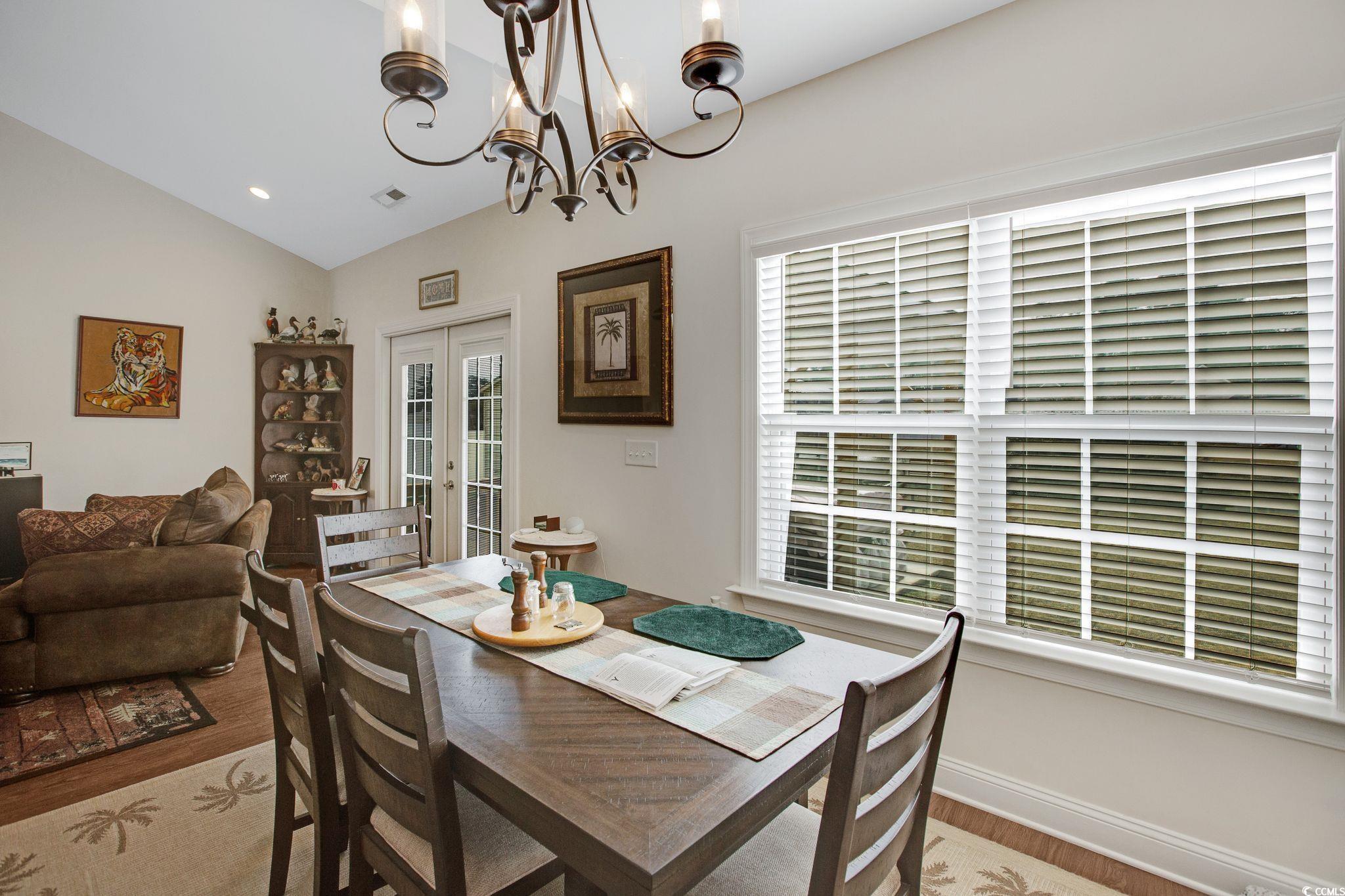 607 Garden Avenue Georgetown, SC 29440 - Photo 11 of 35 Dining area with french doors, a chandelier, vaulted ceiling, and light hardwood / wood-style flooring