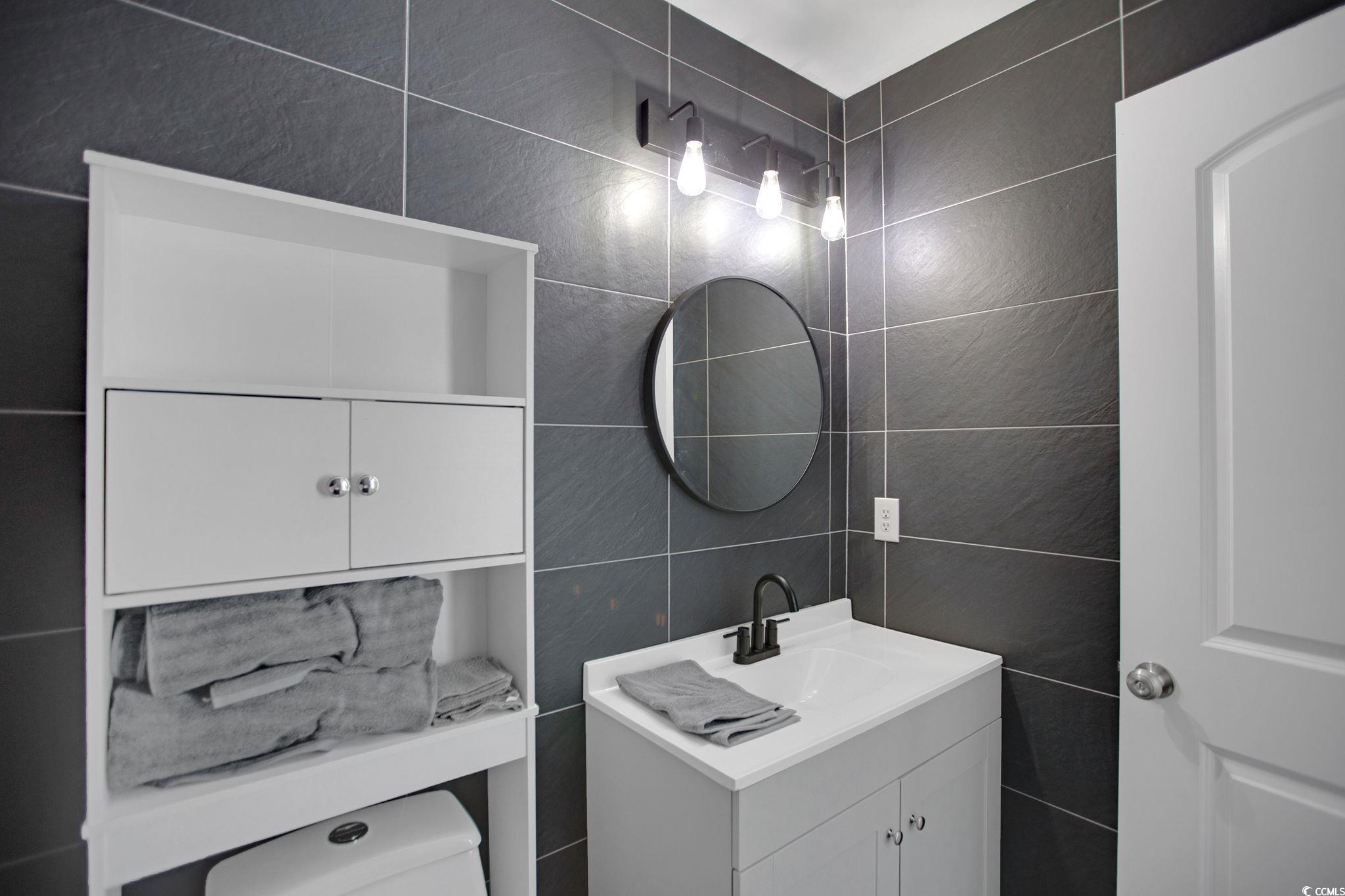 607 Garden Avenue Georgetown, SC 29440 - Photo 23 of 35 Bathroom with vanity, toilet, and tile walls
