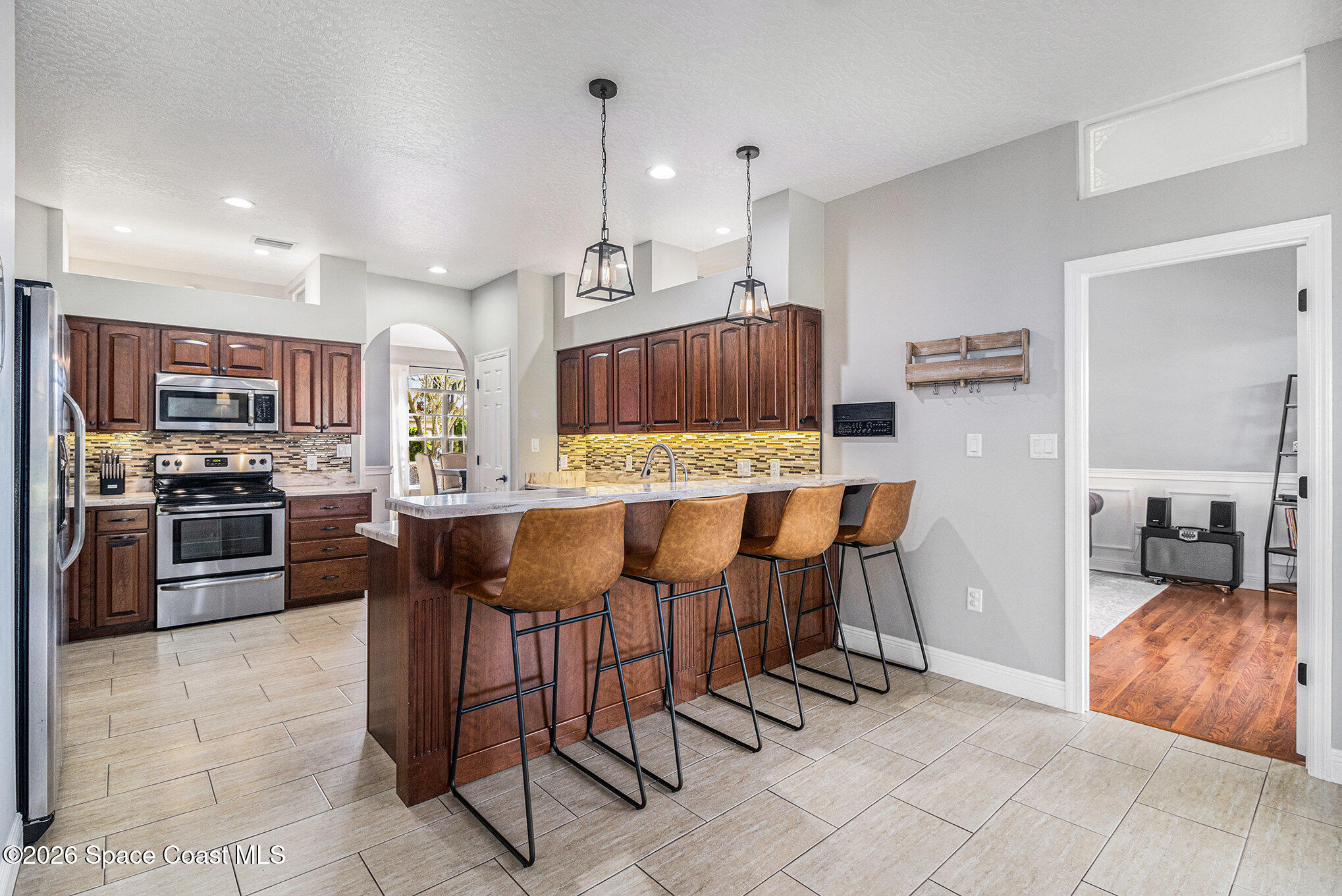 4115 Savannahs Trail Merritt Island, FL 32953 - Photo 11 of 42 a open kitchen with stainless steel appliances kitchen island granite countertop a table and chairs
