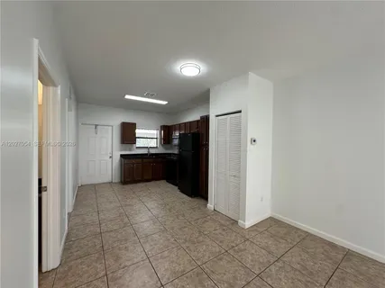 a view of kitchen with kitchen island cabinets and refrigerator