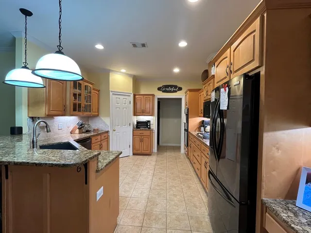 a kitchen with stainless steel appliances granite countertop a refrigerator and a sink