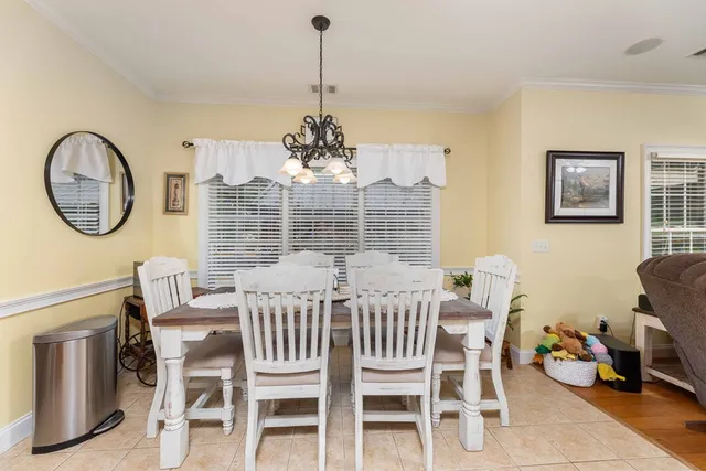 a view of a dining room with furniture a chandelier and wooden floor
