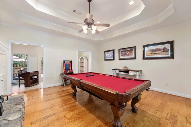 a room with pool table and wooden floor