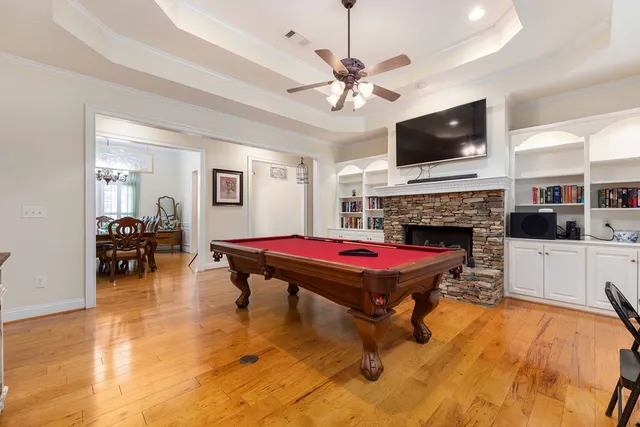 a living room with pool table and a fireplace