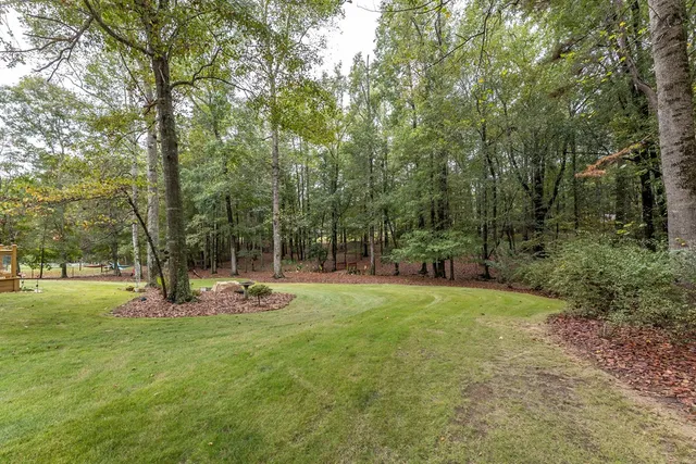 an aerial view of residential house with outdoor space and trees all around