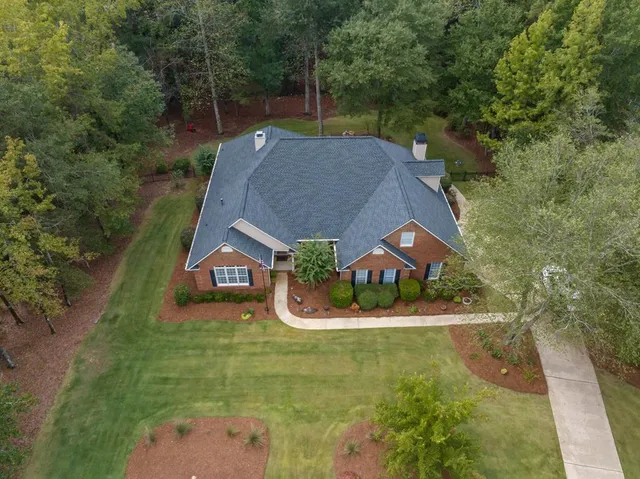 an aerial view of a house with a yard and lake view
