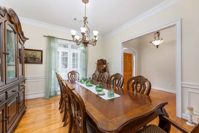 a dining room with furniture a chandelier and wooden floor