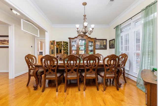 a dining room with furniture a chandelier and wooden floor