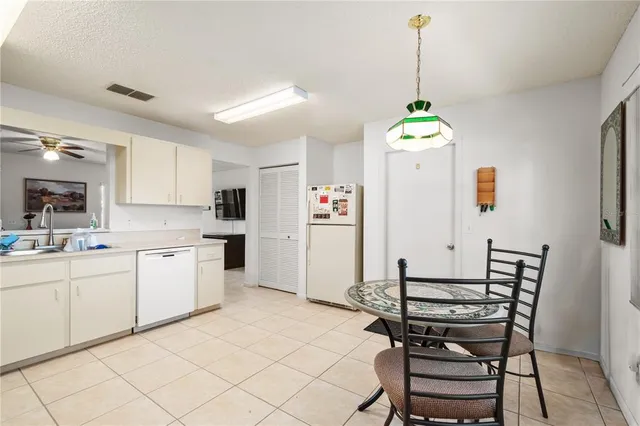 a kitchen with stainless steel appliances kitchen island granite countertop a dining table chairs and sink