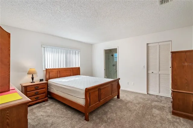 a bedroom with a bed and a refrigerator