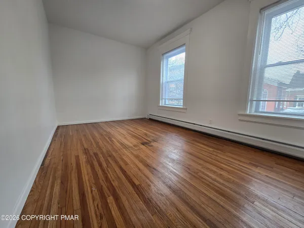 a view of room with window and wooden floor