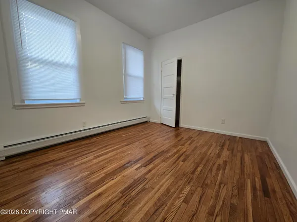 a view of a room with wooden floor and window
