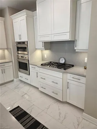 a kitchen with white cabinets and white appliances