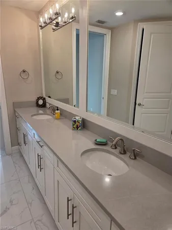 a bathroom with double sink and a mirror