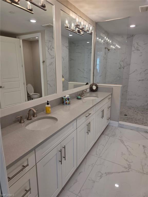 16370 Viansa Way, Unit 6 Naples, FL 34110 - Photo 24 of 27 Bathroom featuring double vanity, light marble finish flooring, a marble finish shower, and recessed lighting