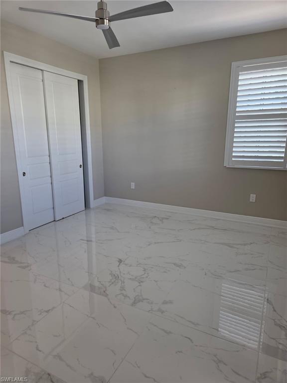 16370 Viansa Way, Unit 6 Naples, FL 34110 - Photo 7 of 27 Unfurnished bedroom featuring ceiling fan and a closet