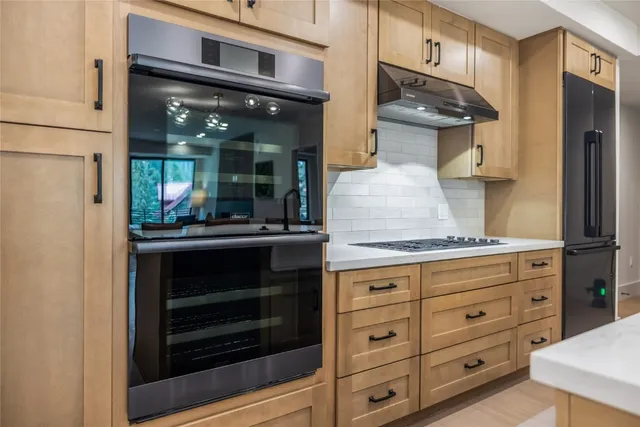 a kitchen with granite countertop white cabinets and stainless steel appliances