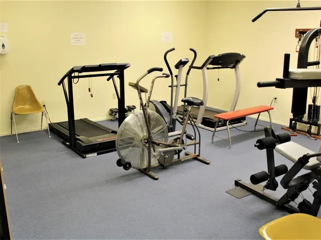 a room with gym equipment and many windows