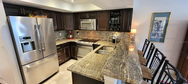 a kitchen with granite countertop a refrigerator and a sink