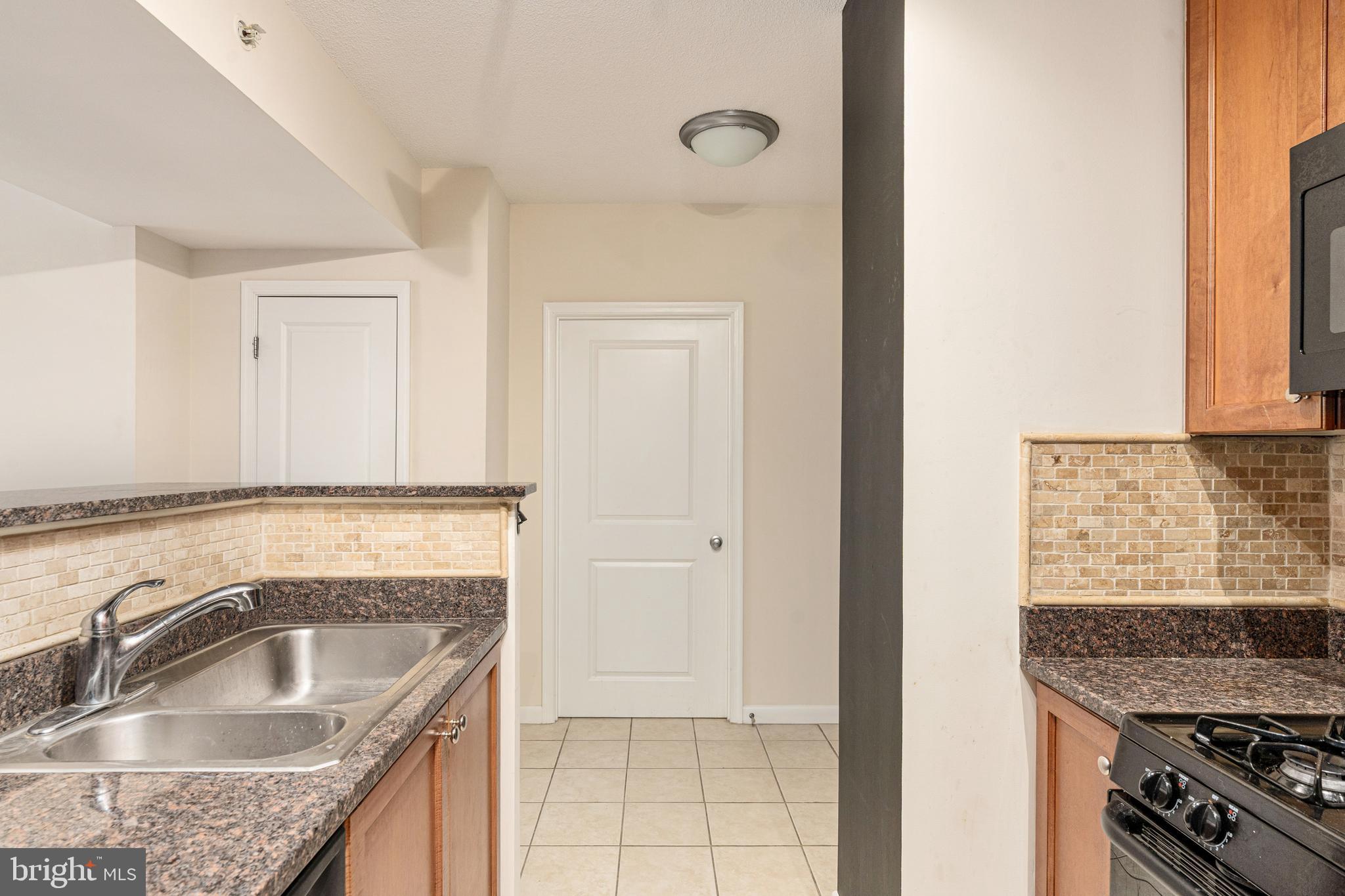 851 North Glebe Road, Unit 1407 Arlington, VA 22203 - Photo 16 of 51 a kitchen with granite countertop a sink and a stove