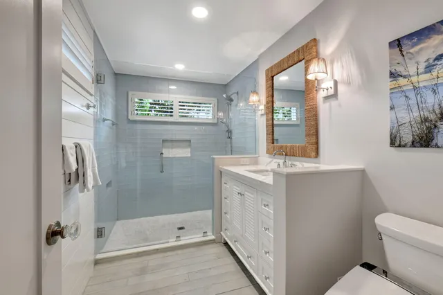 a bathroom with a double vanity sink toilet mirror and bathtub