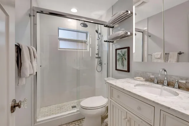 a bathroom with a granite countertop sink toilet and shower