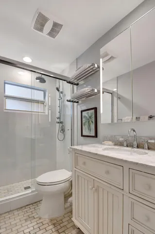 a bathroom with a granite countertop sink toilet and shower