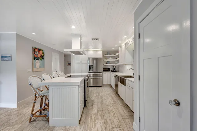 a kitchen with kitchen island a stove a sink and a refrigerator