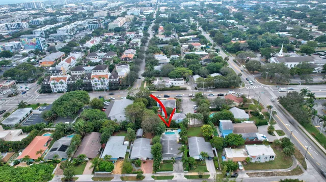 an aerial view of residential houses with outdoor space and trees
