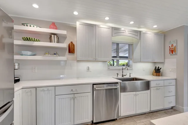 a kitchen with white cabinets and sink