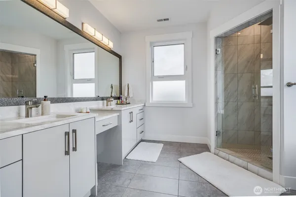 a spacious bathroom with a shower sink and mirror