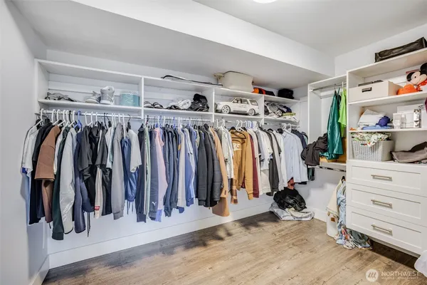 a view of walk in closet with clothes and shoes