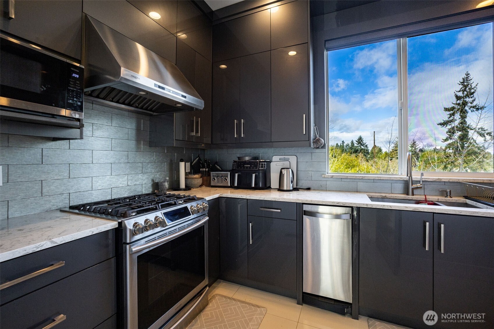 17323 Military Road South SeaTac, WA 98188 - Photo 30 of 40 a kitchen with stainless steel appliances granite countertop a sink a stove and a microwave