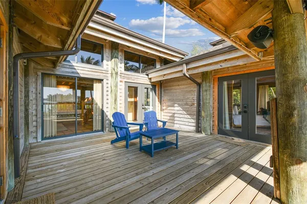 a view of a backyard with a wooden roof and sitting space