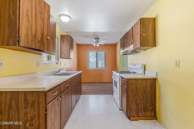 a kitchen with stainless steel appliances granite countertop a sink stove and cabinets
