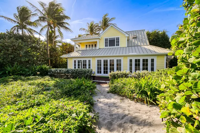 a front view of a house with a garden