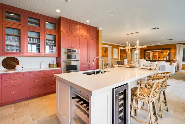 a kitchen with stainless steel appliances kitchen island granite countertop a table chairs in it and wooden floors