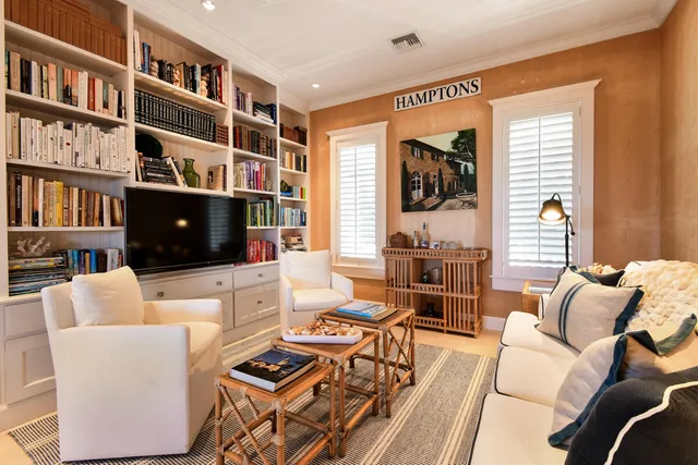 a living room with furniture a flat screen tv and a bookshelf