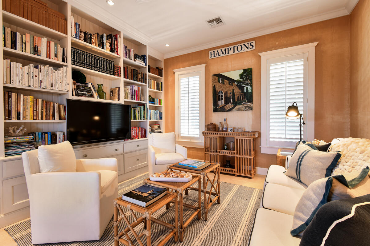 107 North Beach Road Jupiter Island, FL 33455 - Photo 30 of 49 a living room with furniture a flat screen tv and a bookshelf