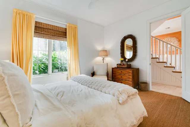 a bedroom with a bed and a large window