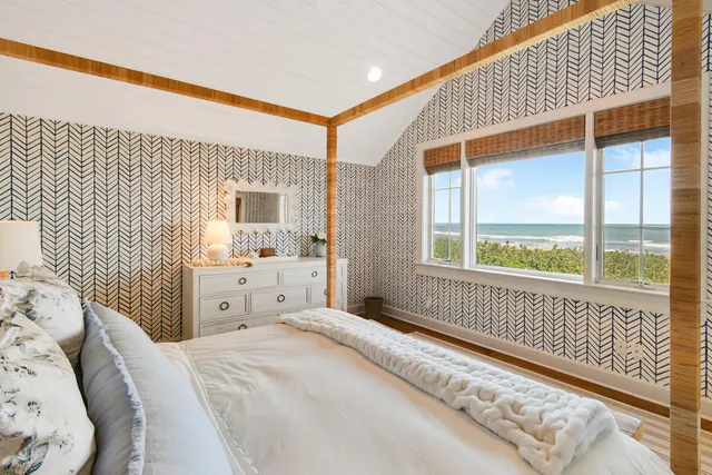 a bedroom with a bed and a large window