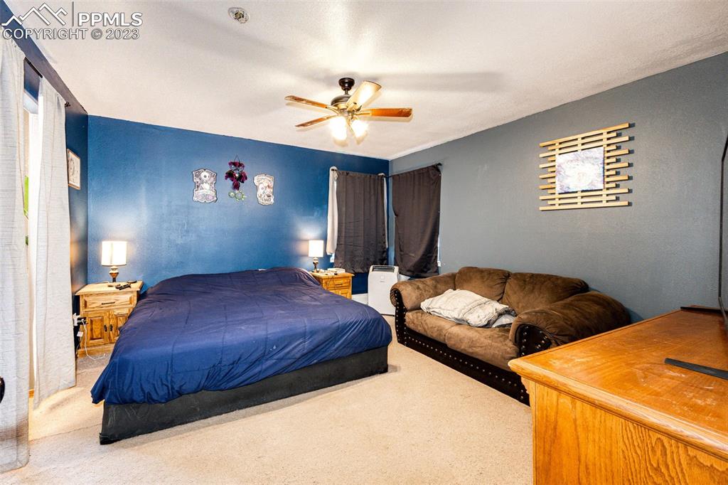 1023 Monument Street Calhan, CO 80808 - Photo 14 of 35 a bedroom with two beds and a chandelier