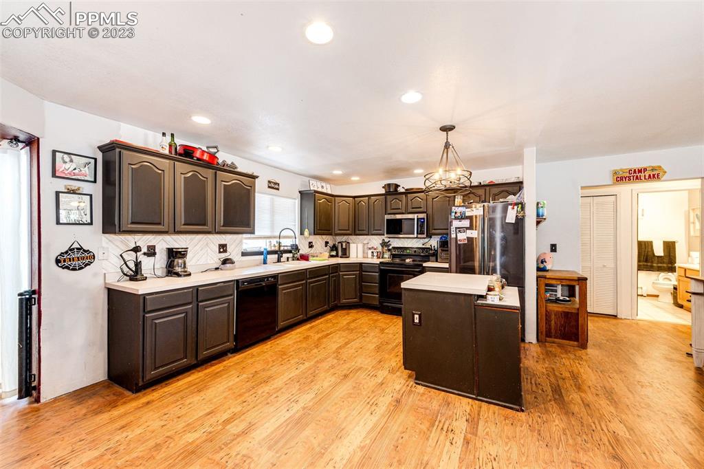 1023 Monument Street Calhan, CO 80808 - Photo 8 of 35 a kitchen with stainless steel appliances kitchen island granite countertop a stove and a refrigerator
