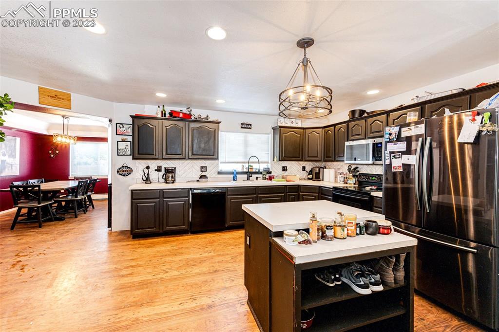 1023 Monument Street Calhan, CO 80808 - Photo 10 of 35 a kitchen with a stove a refrigerator and chandelier