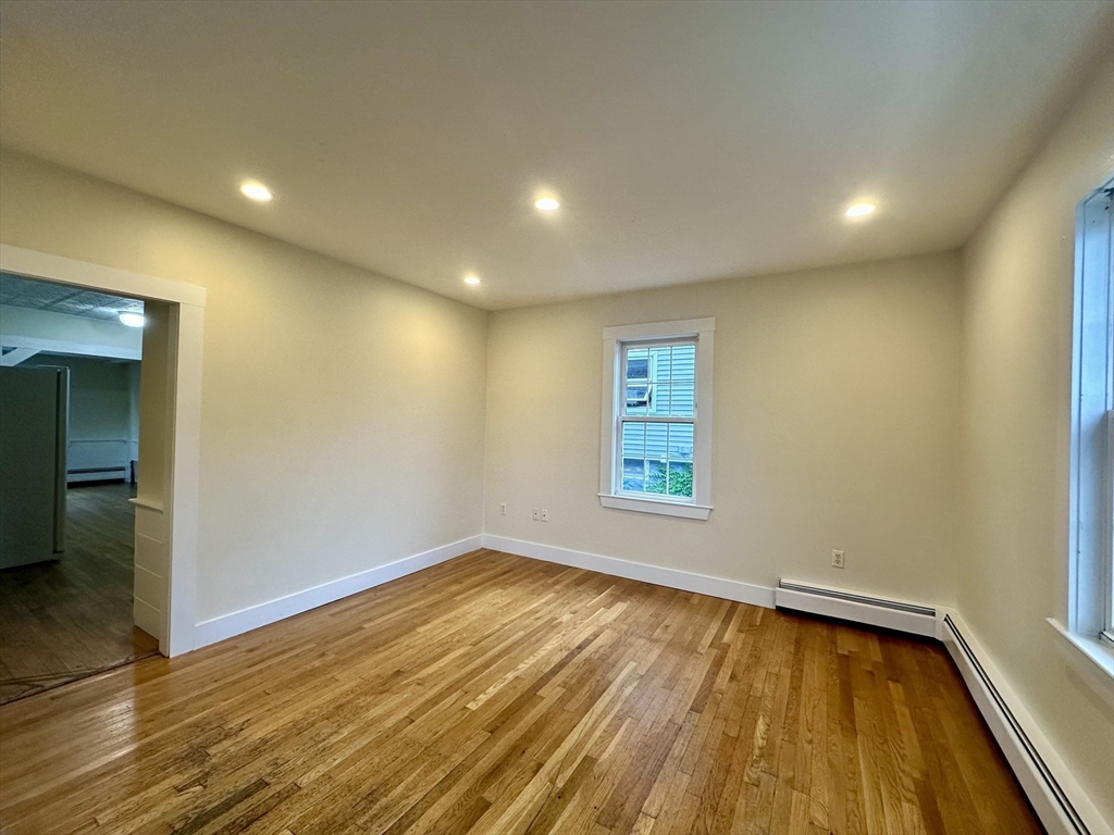 354 University Avenue Lowell, MA 01854 - Photo 6 of 13 an empty room with wooden floor and windows