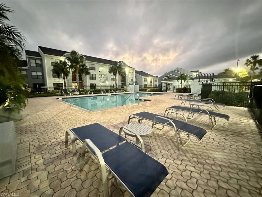 13615 Eagle Ridge Drive, Unit 1614 Fort Myers, FL 33912 - Photo 5 of 34 Open-concept living area featuring wood-finish flooring, a ceiling fan, and a screened balcony